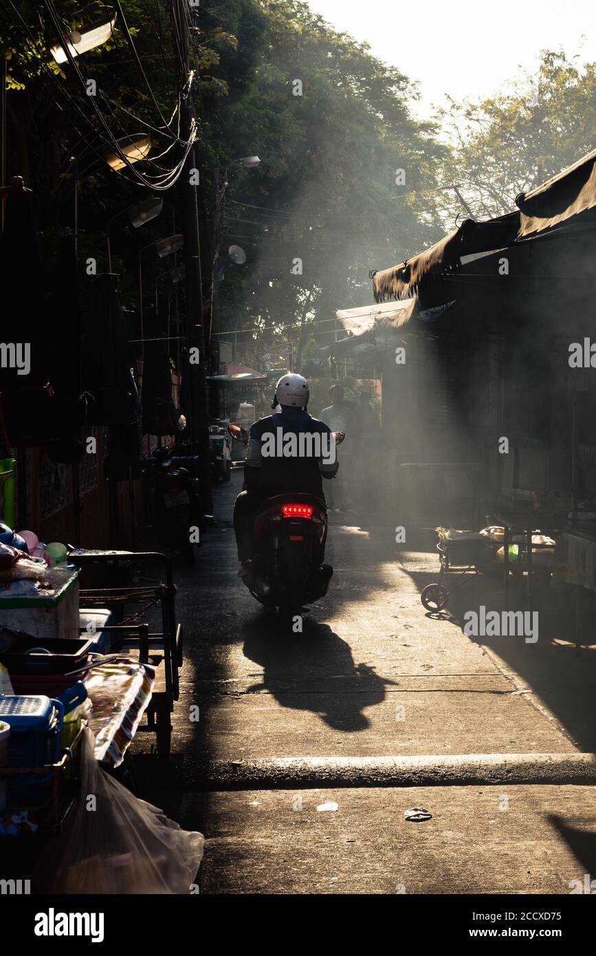 Lumière spectaculaire de l'après-midi dans une ruelle étroite à Thon Buri où les gens du coin cuisent la cuisine de rue Banque D'Images
