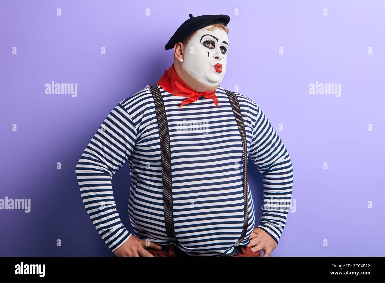 le clown perplexe en gardant les mains sur les hanches en regardant vers le haut. résoudre les problèmes. copier l'espace. jeune homme plumeux prenant la décision Banque D'Images
