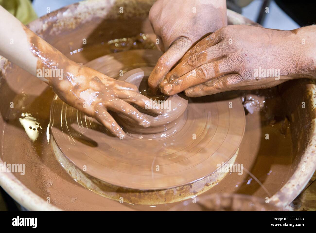 Mains sur une roue de poterie. Main potter. Argile potier créant sur la roue de poterie Banque D'Images