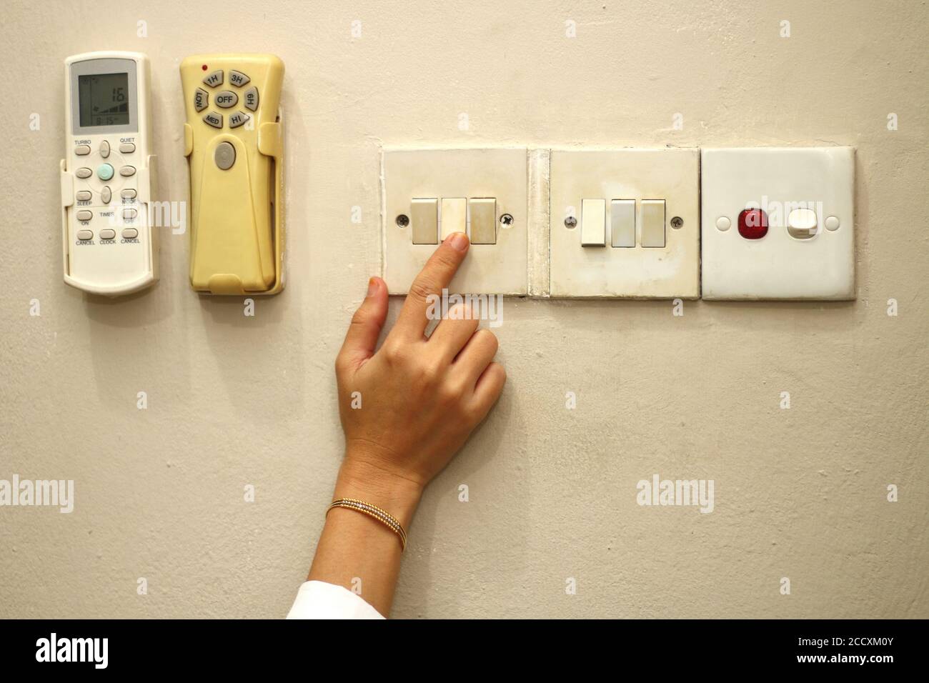 les femmes allument manuellement l'interrupteur d'éclairage Banque D'Images