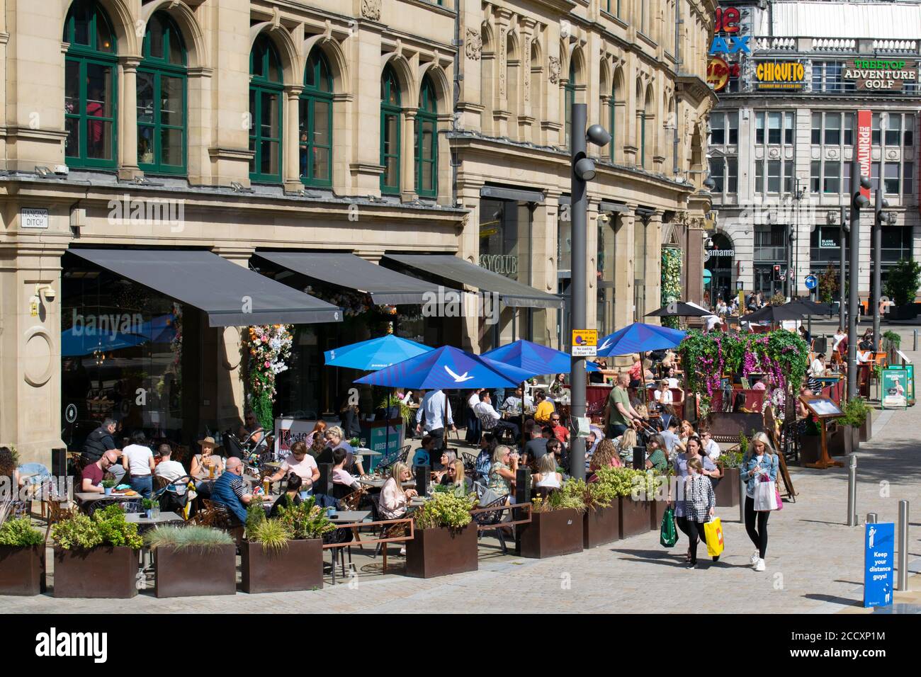 Manger dehors pour aider à la mise en place. La foule devant le restaurant Banyan dans le Corn Exchange, qui construit le programme le lundi. Manchester, Royaume-Uni. Banque D'Images