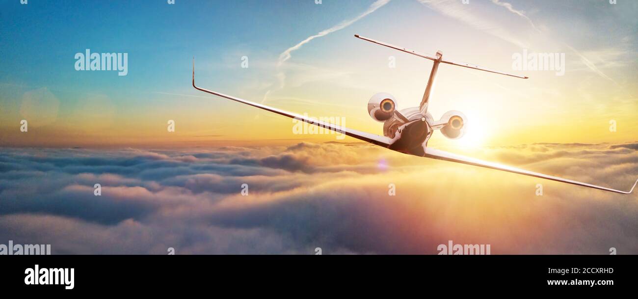 Avion à réaction volant au-dessus des nuages dans beau coucher de la lumière. Concept de voyage et d'affaires. Vue arrière Banque D'Images