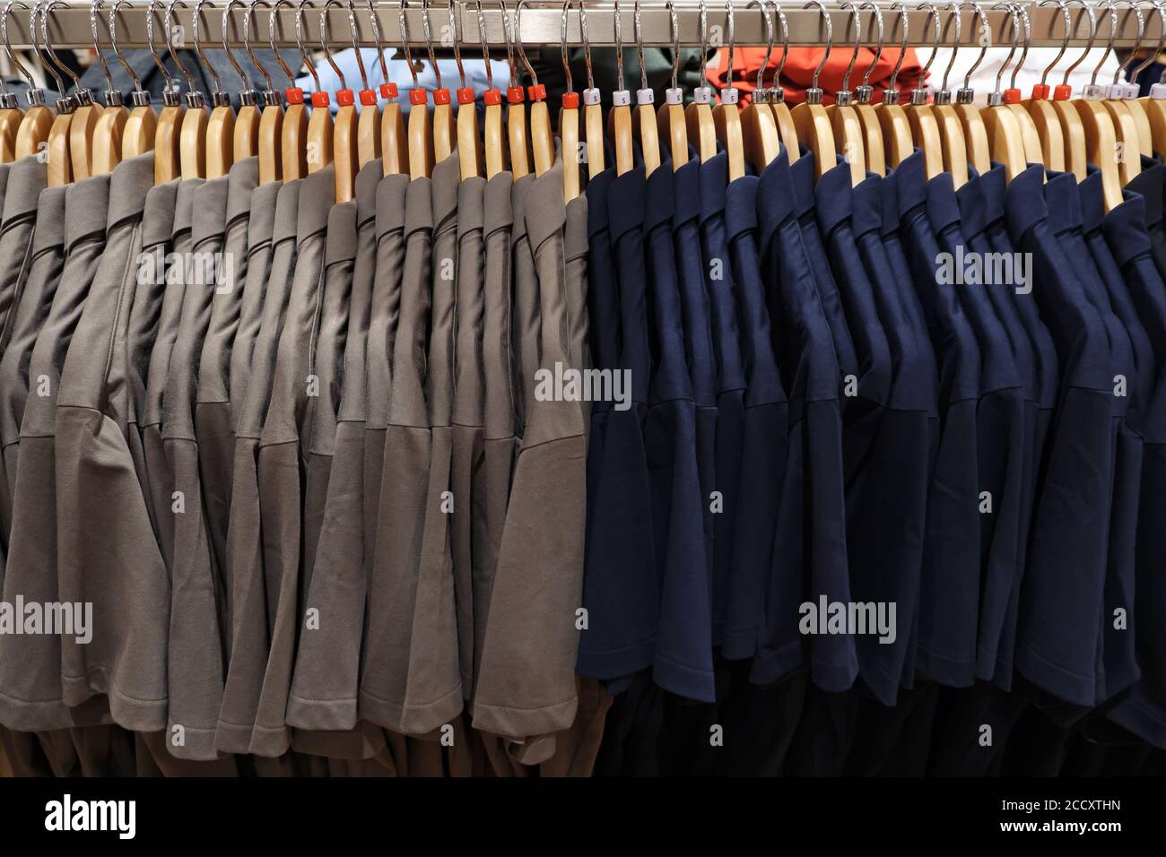 Polos pour hommes de différentes tailles sur cintres. Banque D'Images