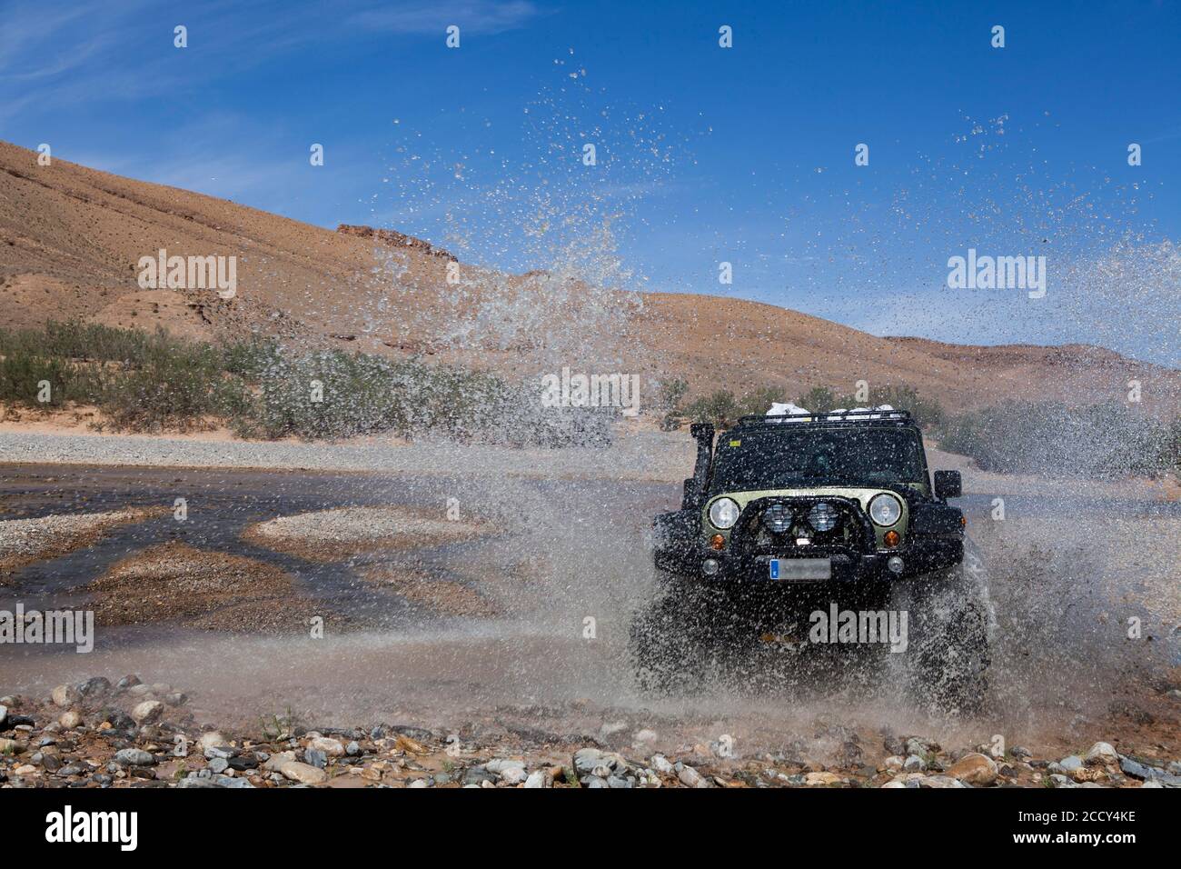 Un véhicule tout-terrain traverse une rivière dans le Moyen Atlas, au Maroc Banque D'Images