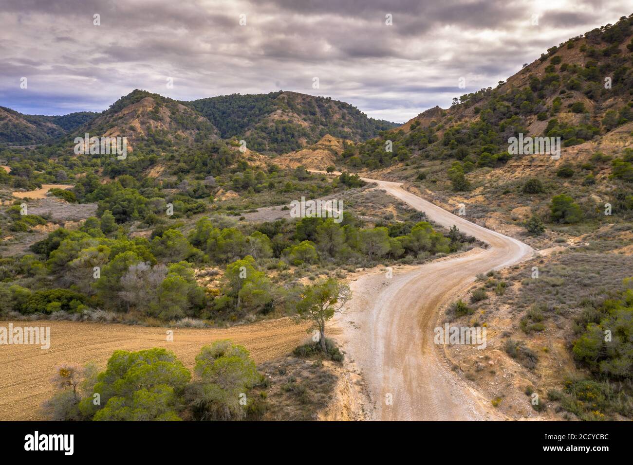 Vue aérienne de la route de terre à travers le paysage aride du Castejon de Monegros dans les montagnes d'Alcubierre, Aragon, Espagne Banque D'Images