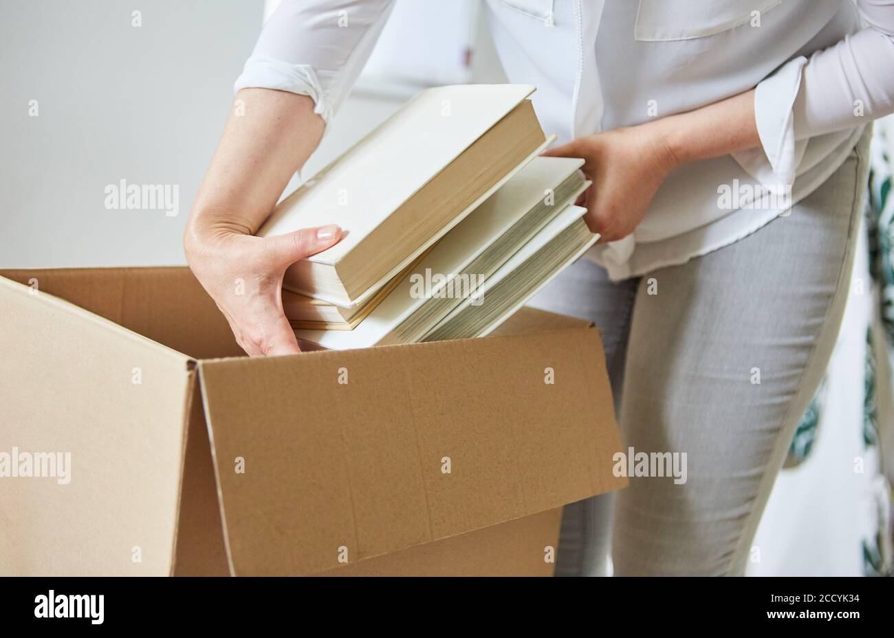 Femme livre dans une boîte mobile pour se déplacer vers la nouvelle maison Banque D'Images