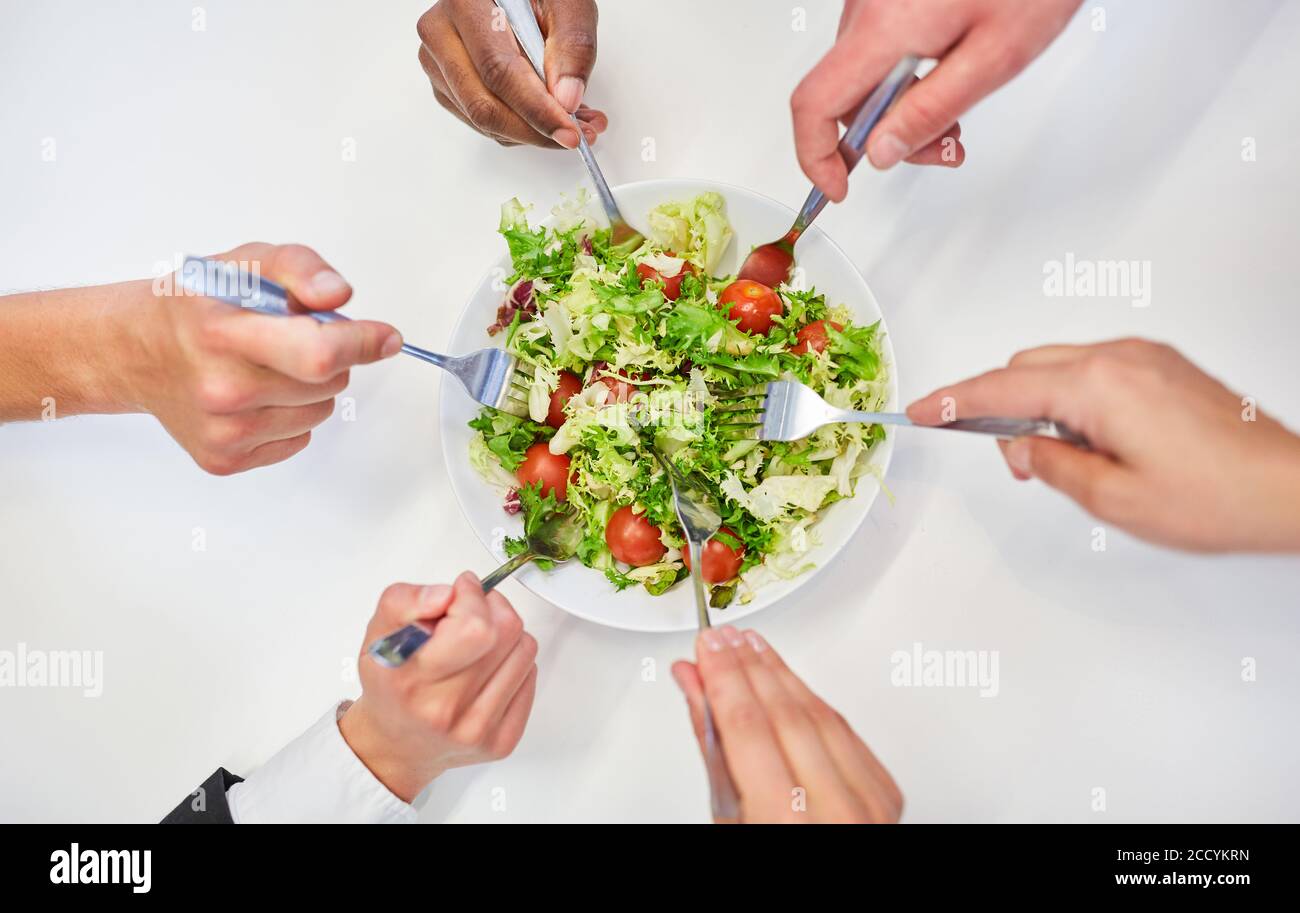Vous devez faire des mains avec des fourchettes de l'équipe d'affaires tout en mangeant de la salade pour une alimentation saine Banque D'Images