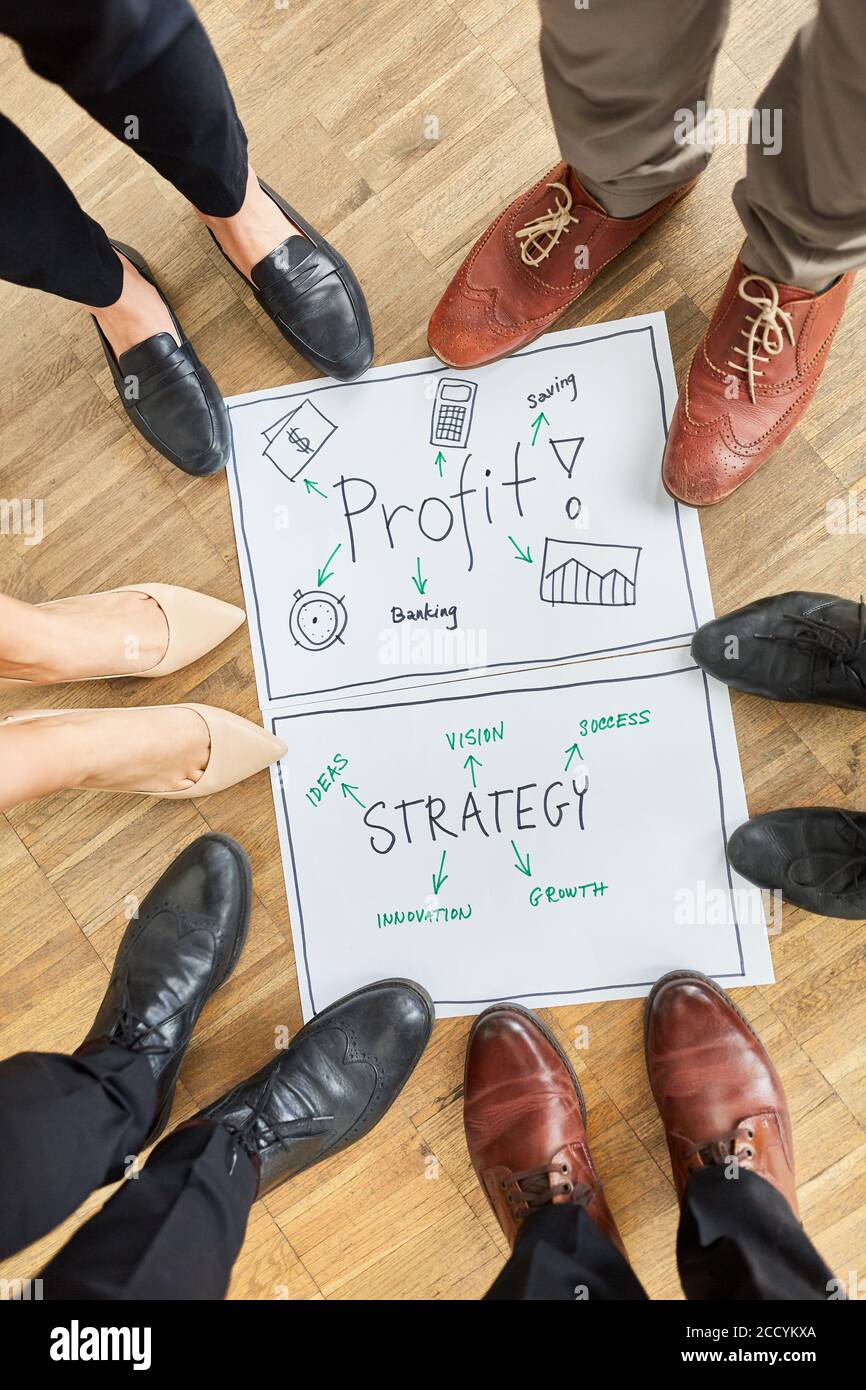 Les pieds de gens d'affaires dans un atelier de brainstorming sur le profit et stratégie Banque D'Images