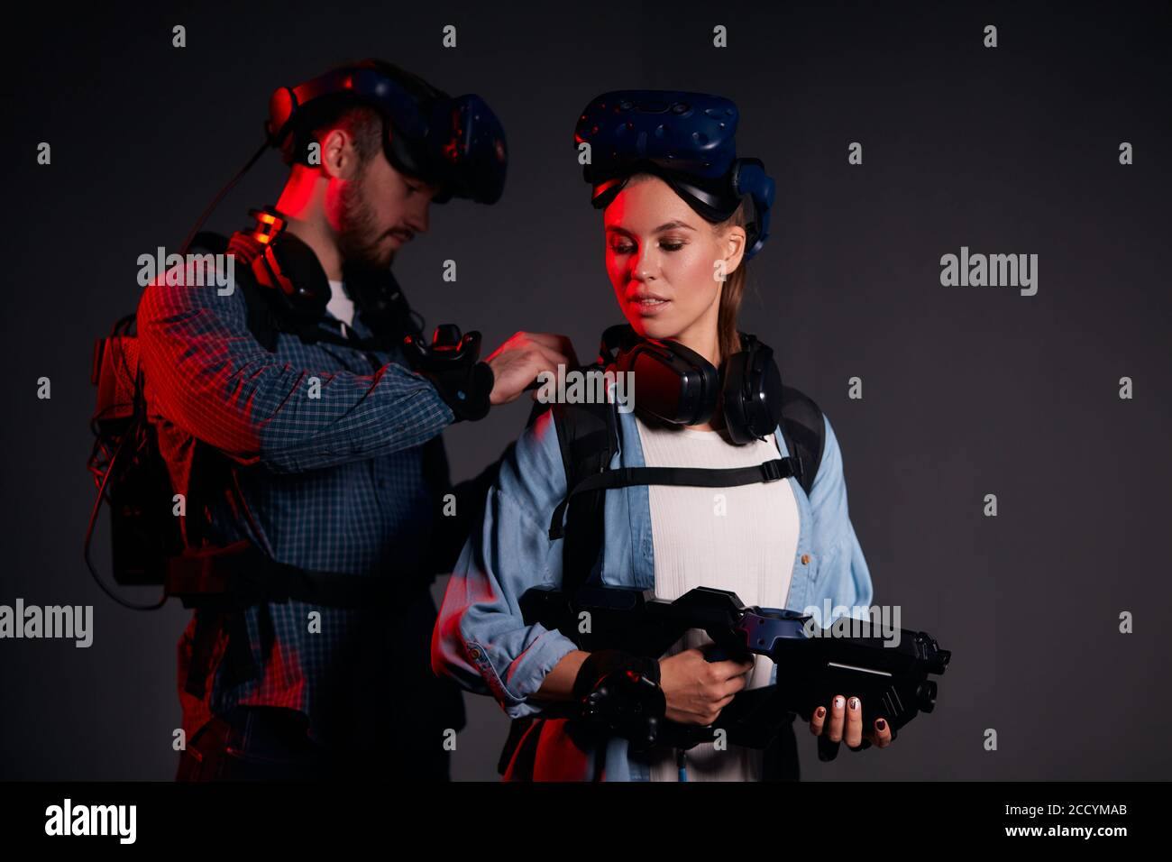 Les jeunes amis du caucase s'aident mutuellement à porter des vêtements spéciaux pour le jeu de la réalité virtuelle Banque D'Images