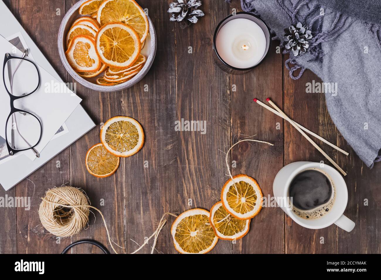 Séchez les oranges, le café et la bougie sur une table en bois. Banque D'Images