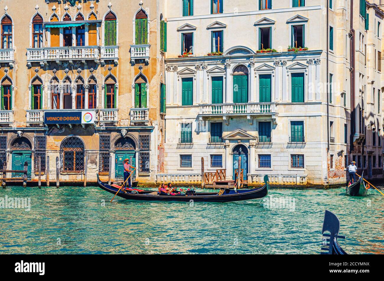 Venise, Italie, 13 septembre 2019 : gondolier et touristes en gondole bateau traditionnel naviguant sur l'eau du Grand Canal avec architecture vénitienne typique bâtiments colorés arrière-plan Banque D'Images