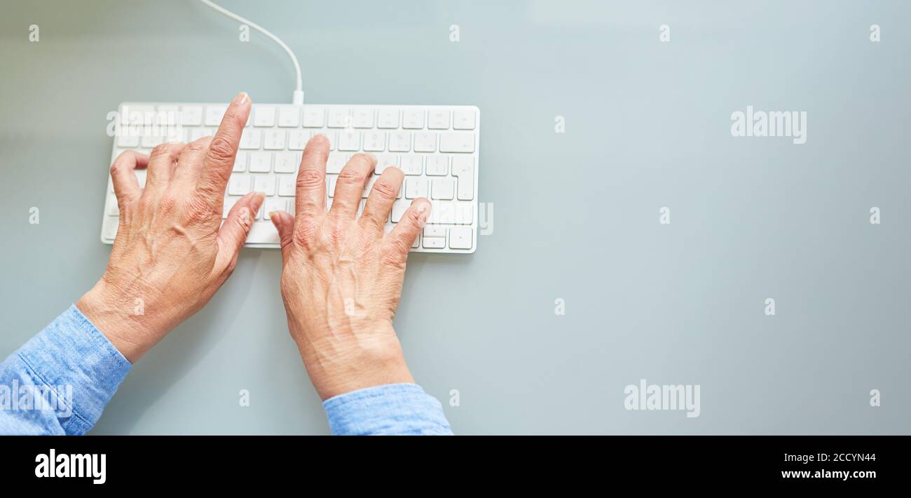 Deux mains de senor femelle écrivent sur le clavier de l'ordinateur Banque D'Images