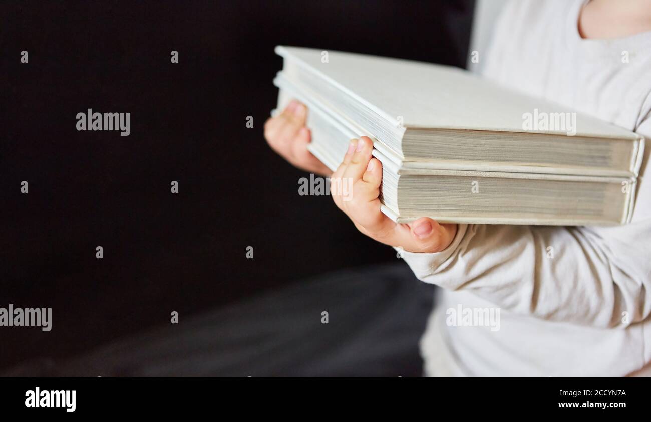 La femme porte des livres à emprunter dans la bibliothèque ou comme un symbole de la connaissance Banque D'Images
