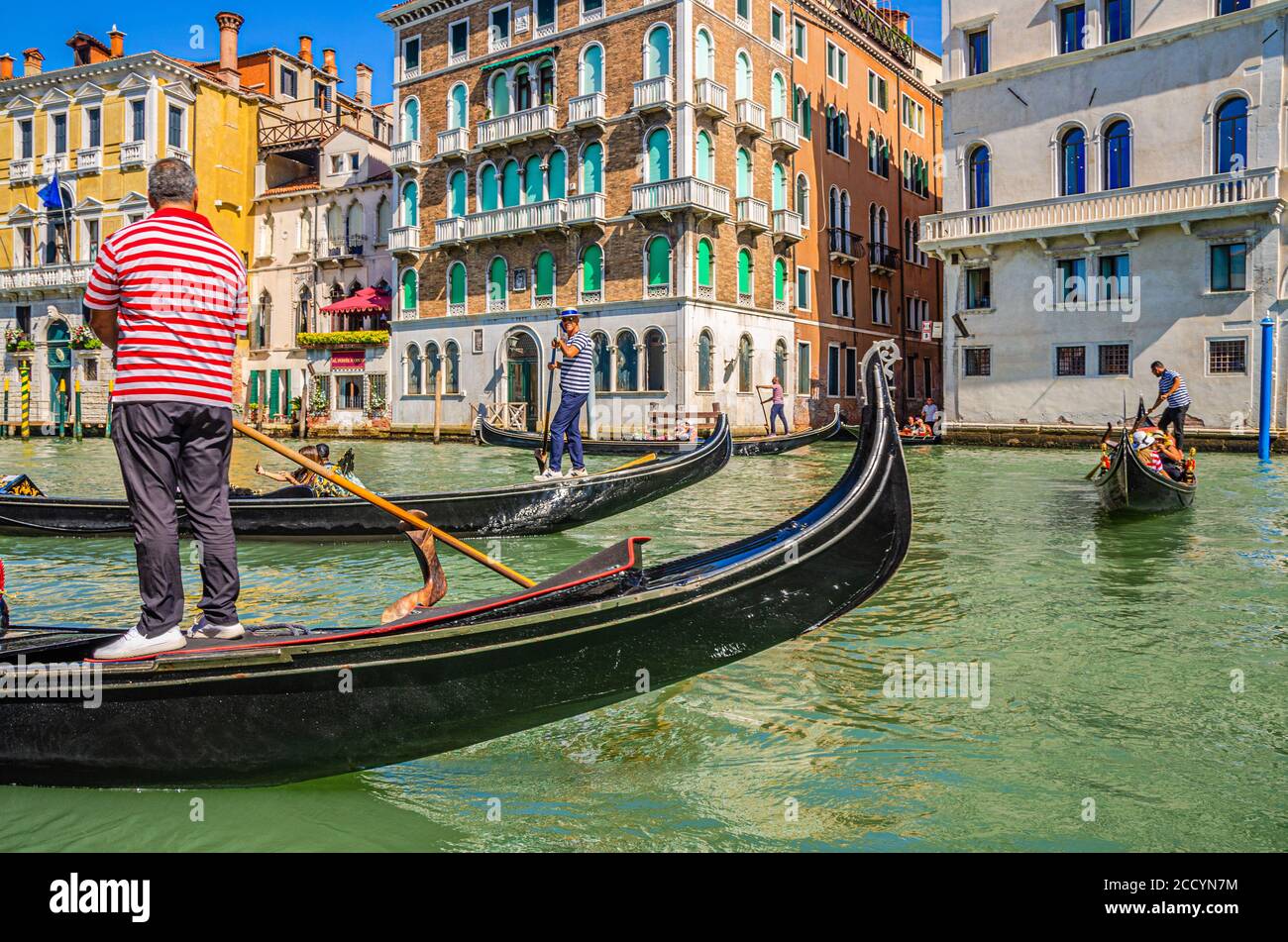 Venise, Italie, 13 septembre 2019 : gondolier et touristes en gondole bateau traditionnel naviguant sur l'eau du Grand Canal avec architecture vénitienne typique bâtiments colorés arrière-plan Banque D'Images