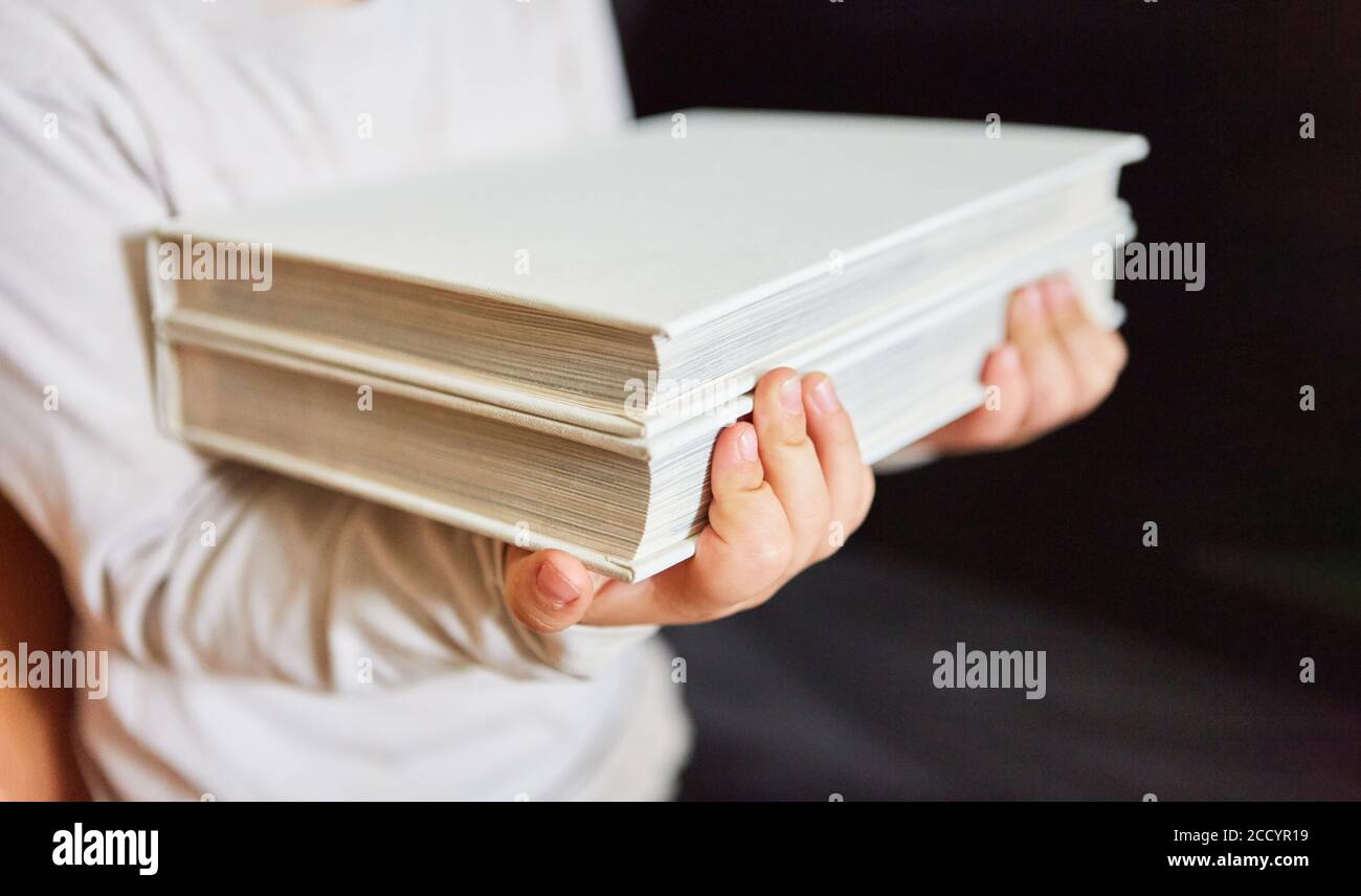 La femme porte une pile de livres à emprunter dans un bibliothèque ou bibliothèque Banque D'Images