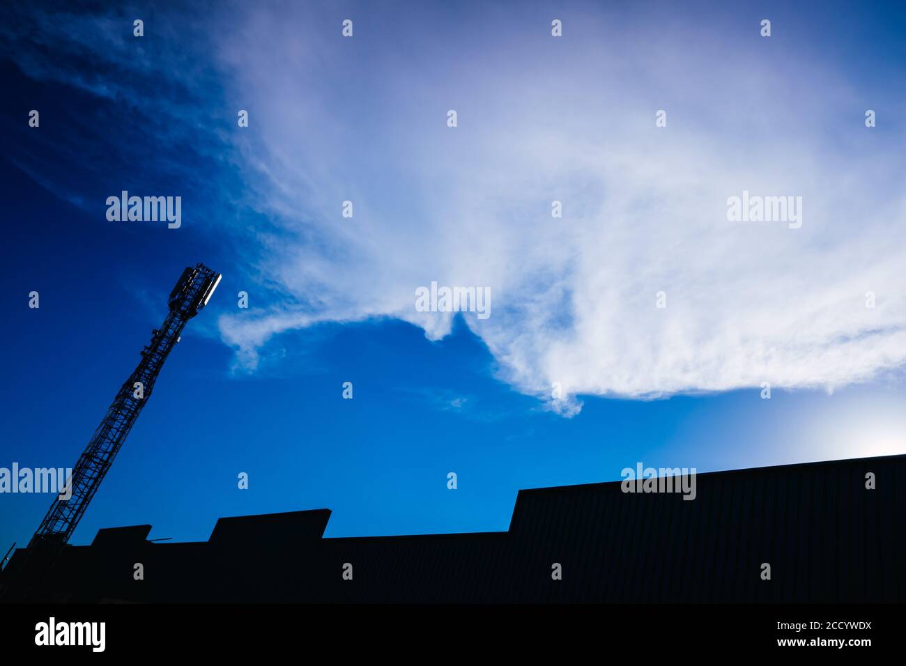 Silhouette d'une tour de télécommunications avec antennes mobiles avec espace de copie sur fond bleu ciel. Banque D'Images