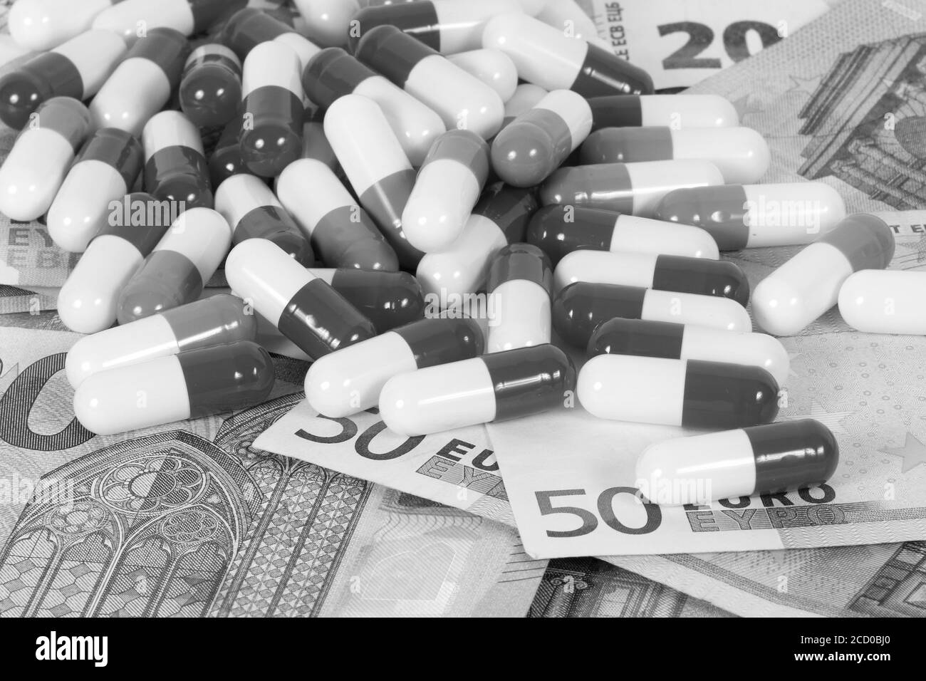 Gros plan en échelle de gris des pilules médicales et des factures d'euros Banque D'Images