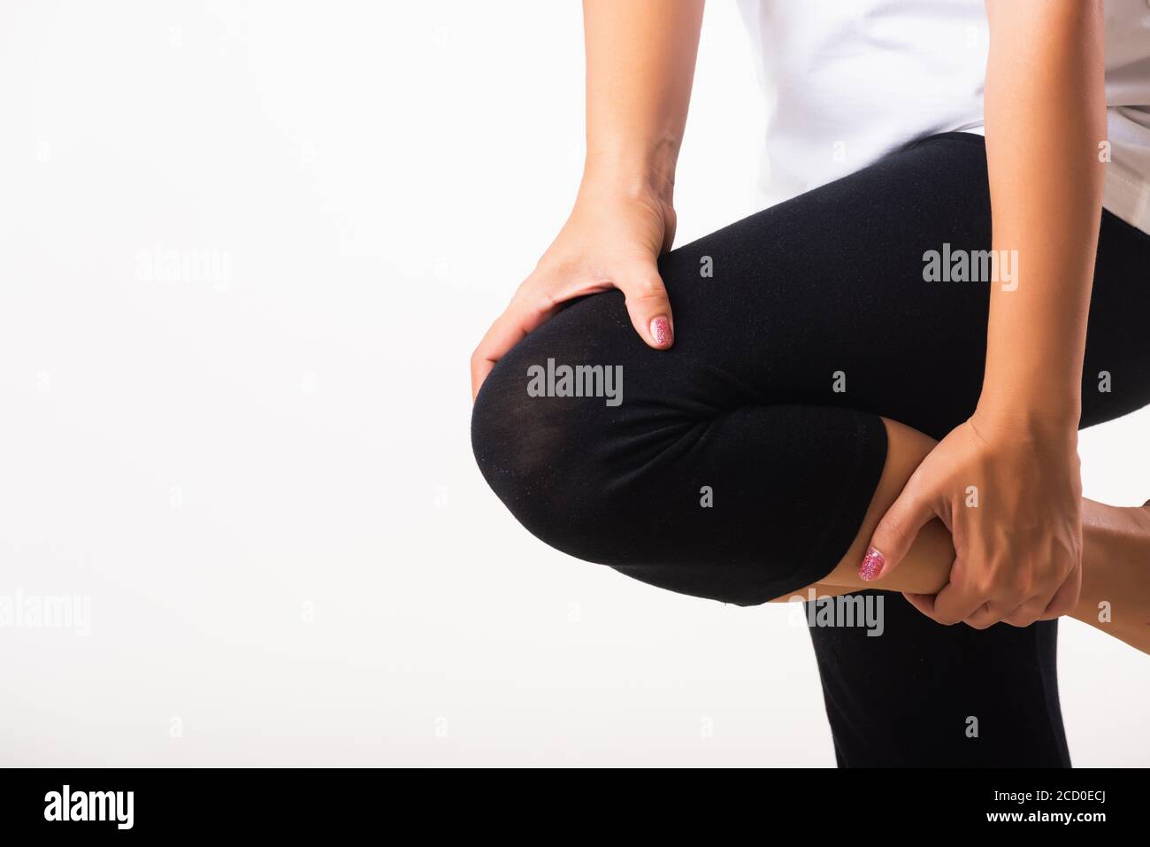 Gros plan de la jeune femme douleurs à souffrir de la douleur genou et elle utilise main joint tenir genou agonie, studio shot isolé sur fond blanc rhumatism santé Banque D'Images