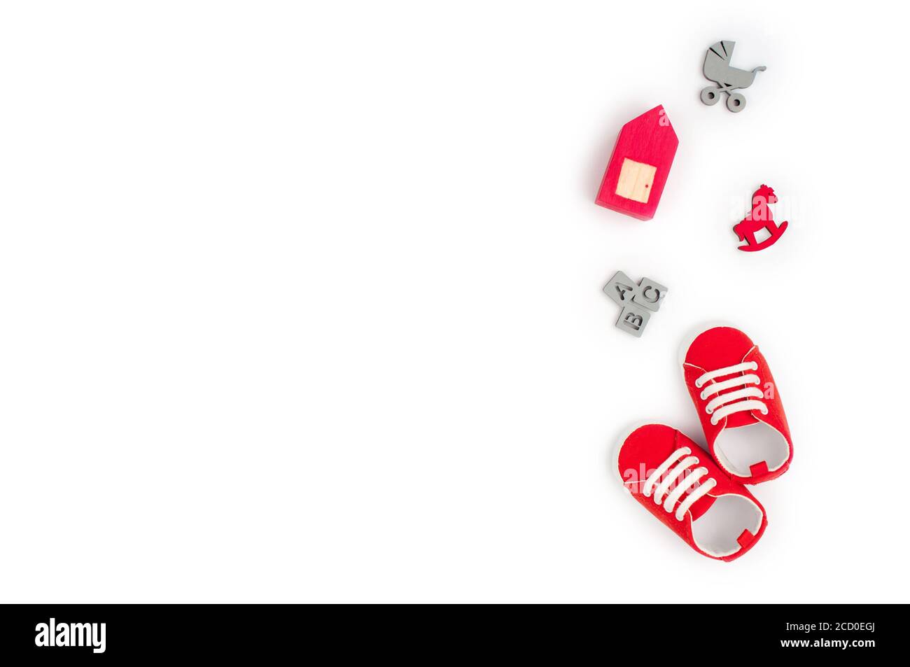 Chaussures pour bébé et jouets en bois isolés sur fond blanc avec espace vide pour le texte ; vue de dessus, plat Banque D'Images