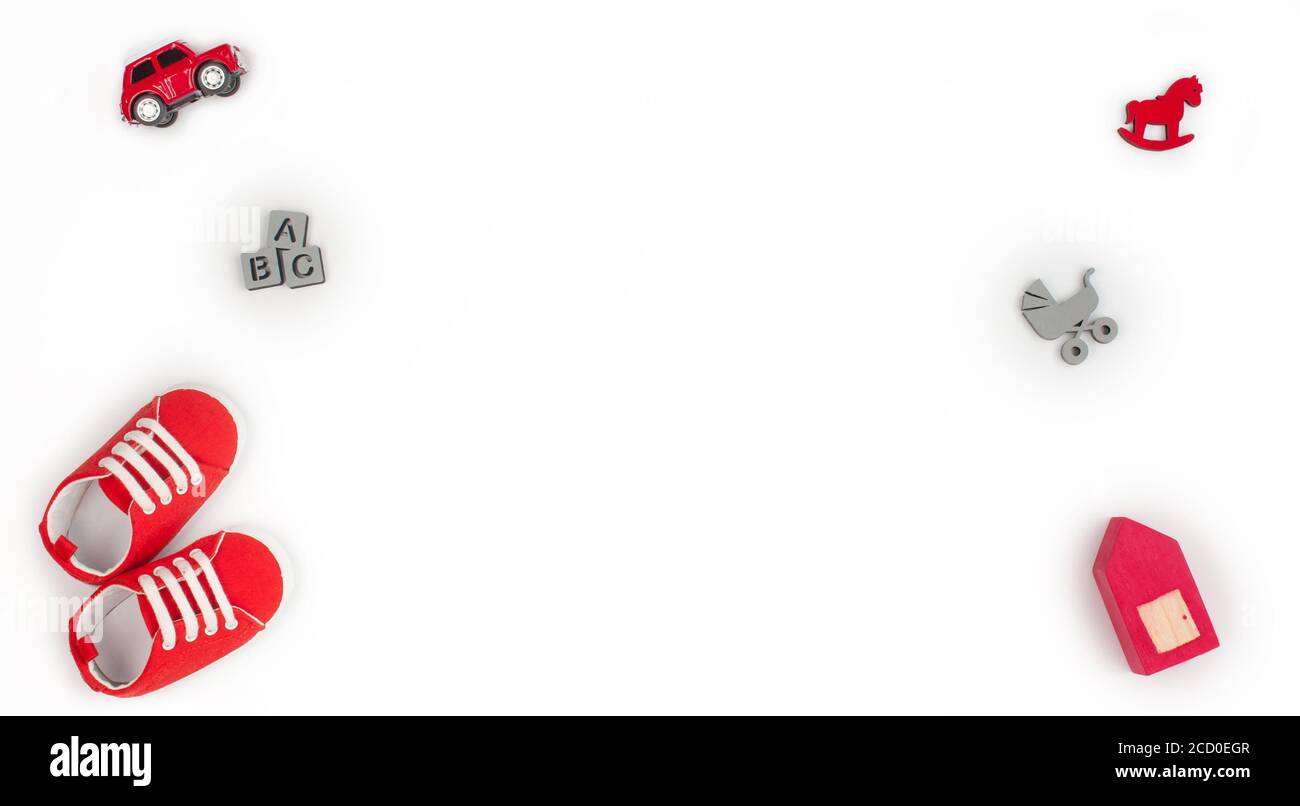 Chaussures pour bébé et jouets en bois isolés sur fond blanc avec espace vide pour le texte ; vue de dessus, plat Banque D'Images