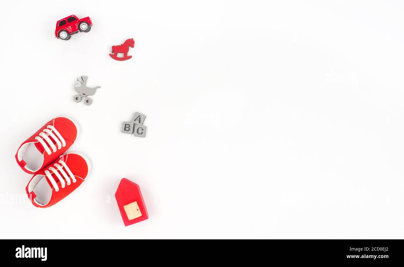 Chaussures pour bébé et jouets en bois isolés sur fond blanc avec espace vide pour le texte ; vue de dessus, plat Banque D'Images