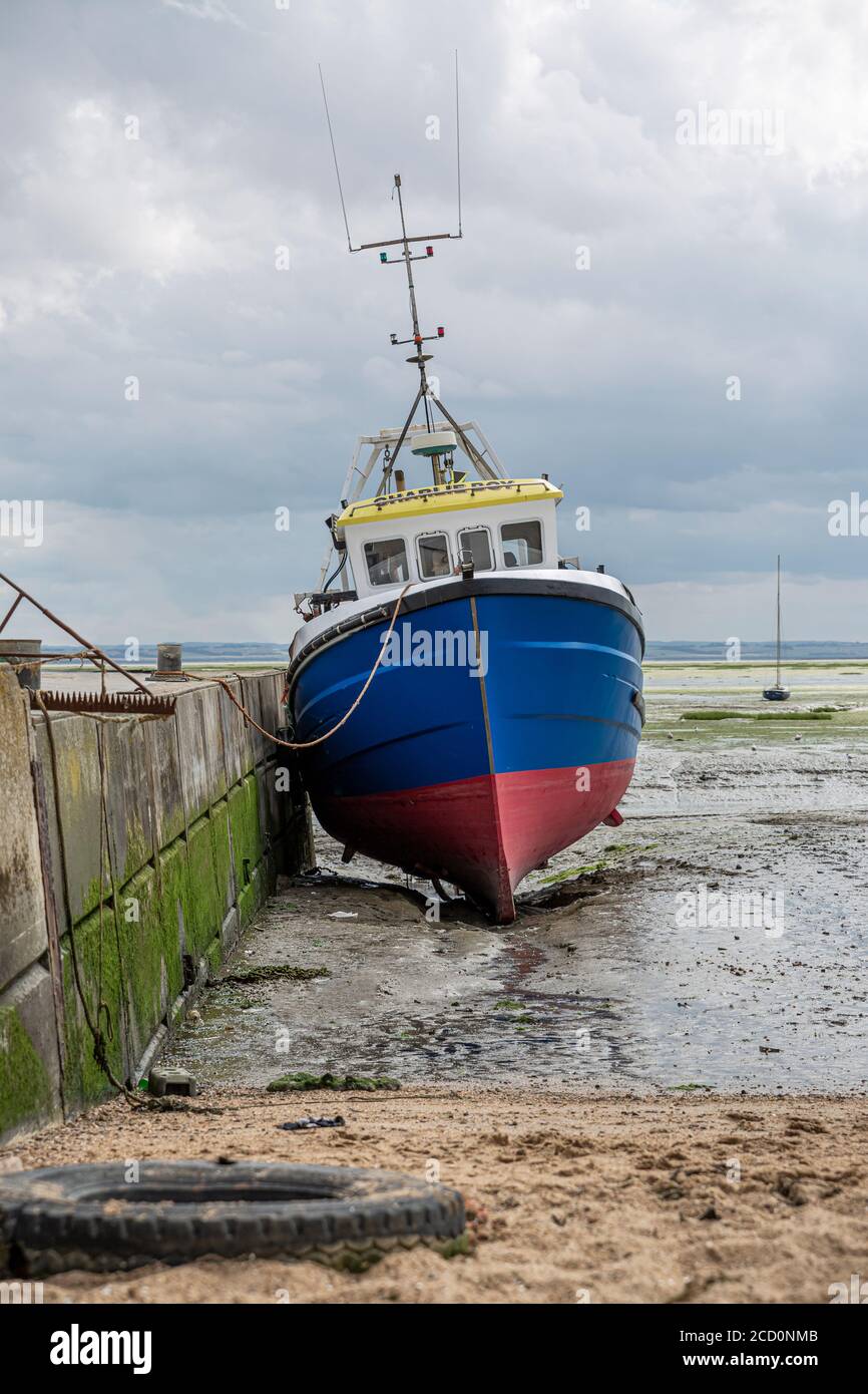 Bateau bleu pêcheur coincé sur la plage à marée basse à Leigh-on-Sea, Royaume-Uni. Banque D'Images