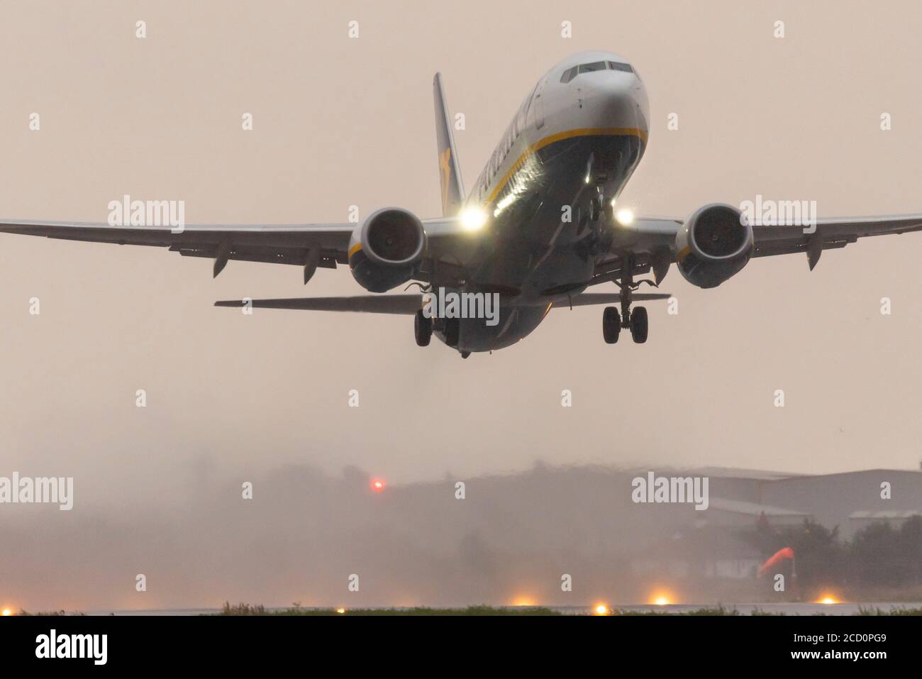 Décollage du Boeing 737 de Ryanair à l'aéroport Southend de Londres, dans l'Essex, au Royaume-Uni, sous une forte pluie, avec des gaz d'échappement produisant un nuage d'humidité de la piste mouillée. Climat Banque D'Images