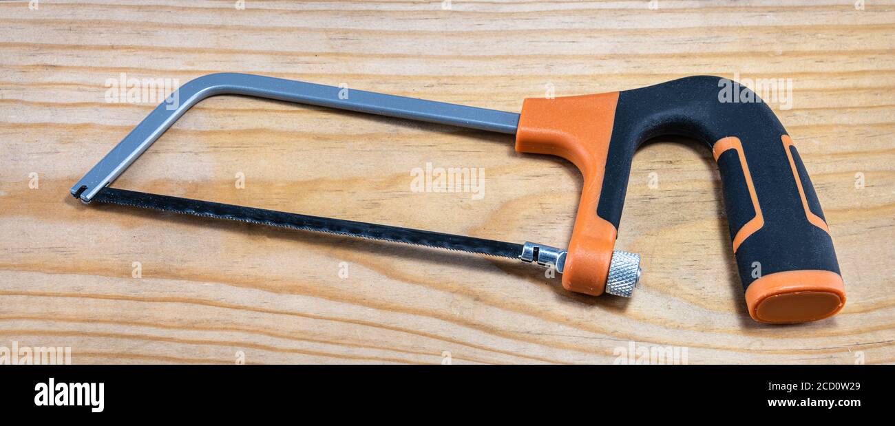 Scie à métaux sur une planche de bois rugueuse Banque D'Images