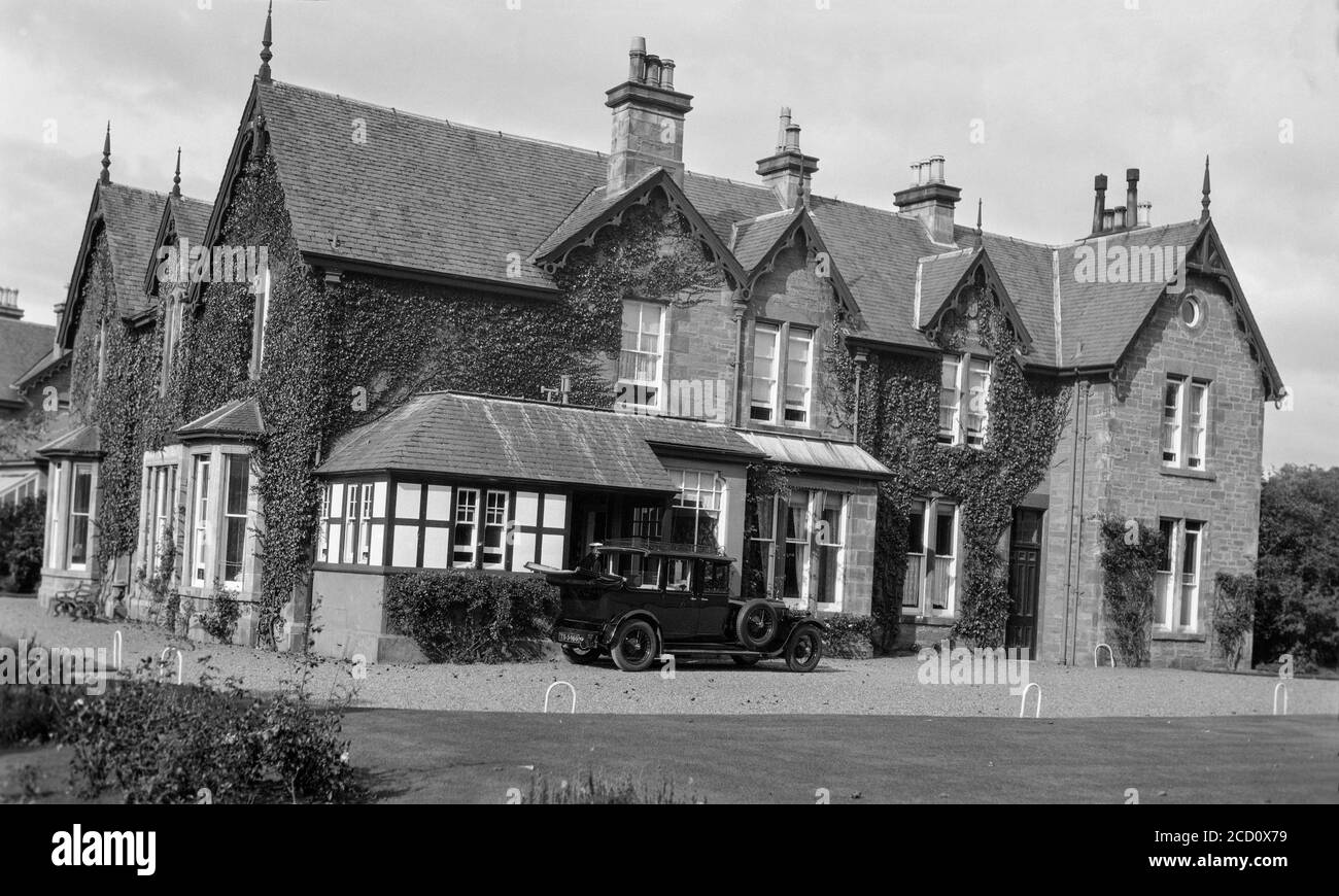 Photographie en noir et blanc des années 1920 montrant une voiture de l'époque, numéro d'immatriculation TS 5466, garée à l'extérieur d'une grande maison à Tayside, en Écosse. Banque D'Images