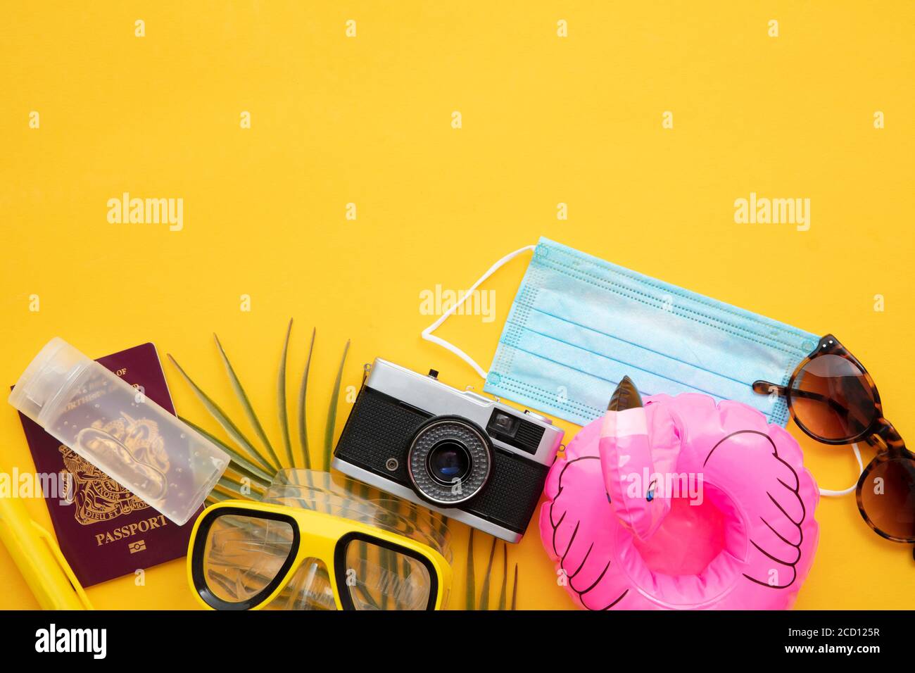 Fond de voyage Covid. Articles essentiels pour les fêtes avec masque facial Banque D'Images
