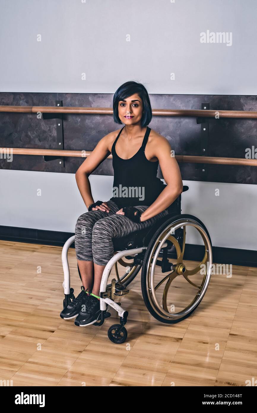 Une femme paraplégique prenant une pause dans un gymnase après avoir fait de l'exercice dans une installation de loisirs : Sherwood Park, Alberta, Canada Banque D'Images