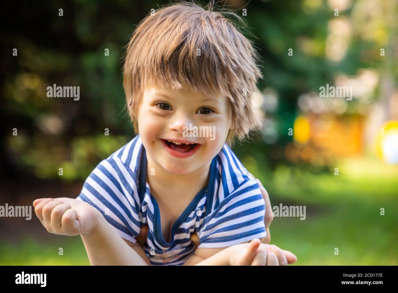 Portrait de bébé garçon avec le syndrome de Down jouant en été jour sur la nature Banque D'Images