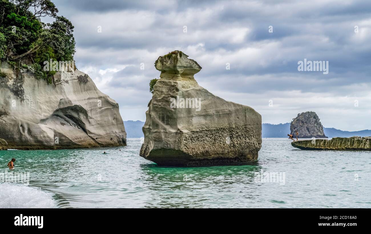 Accessible uniquement à pied ou en bateau, la célèbre crique de la Cathédrale est l'un des sites incontournables de la Coromandel.Les nageurs apprécient la plage et jouent... Banque D'Images