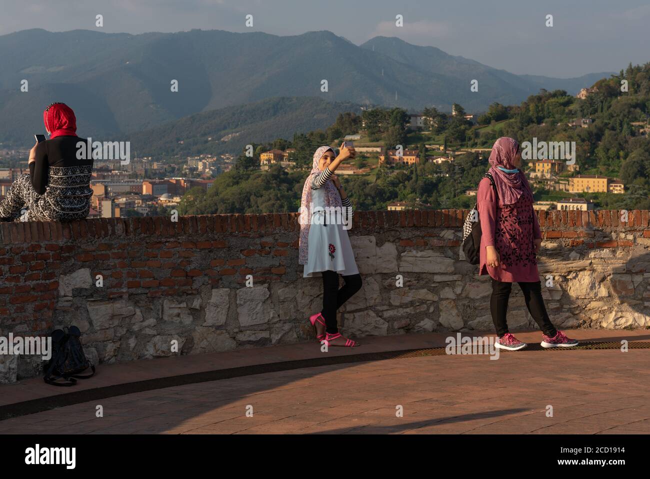 Egyptiennes avec smartphon sur le toit-terrasse avec vue aérienne de la vieille ville italienne de Brescia. Banque D'Images