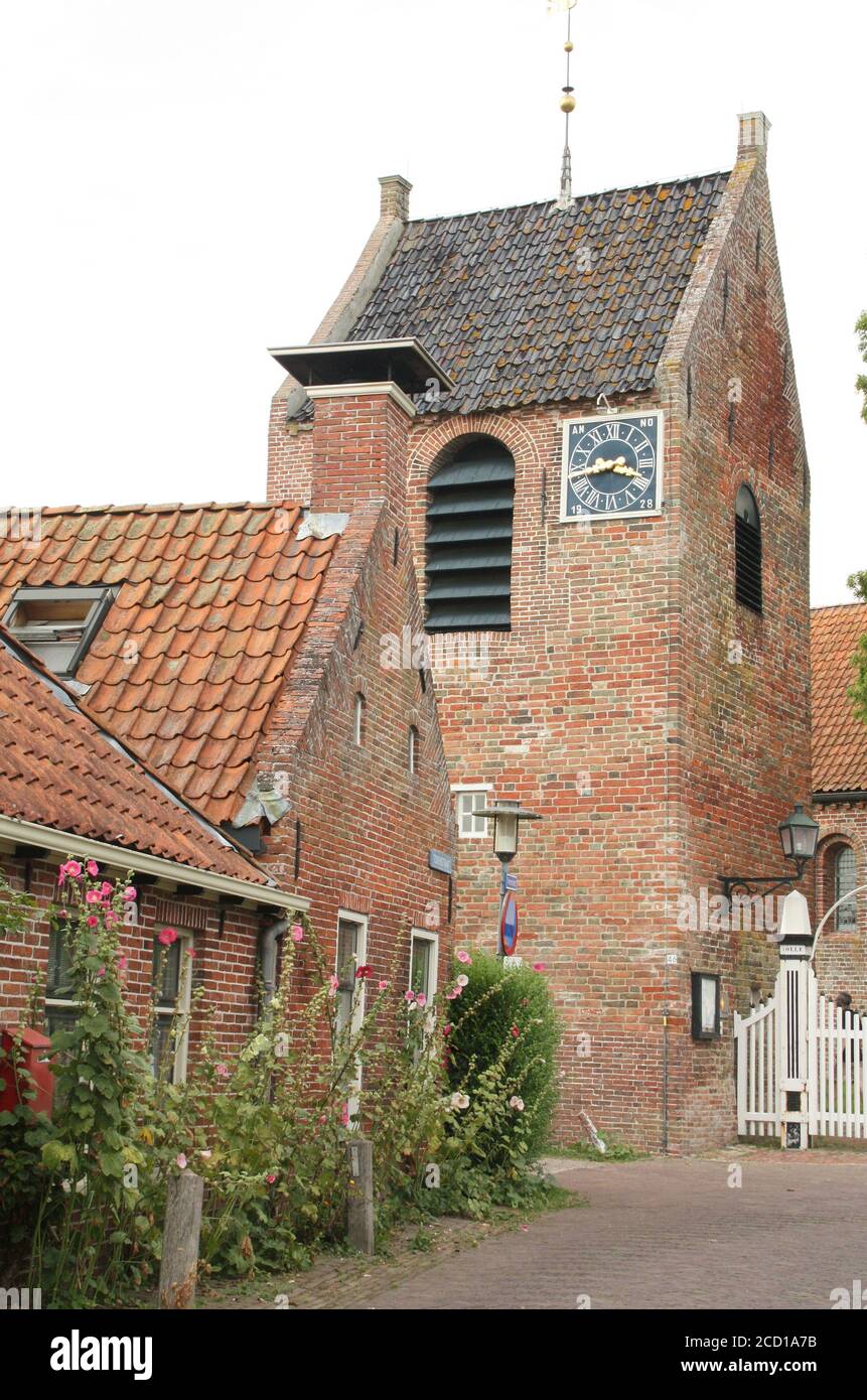 Ezinge. Août-16-2020. La tour de l'église d'Ezége et une maison historique dans le village d'Ezége. Pays-Bas Banque D'Images