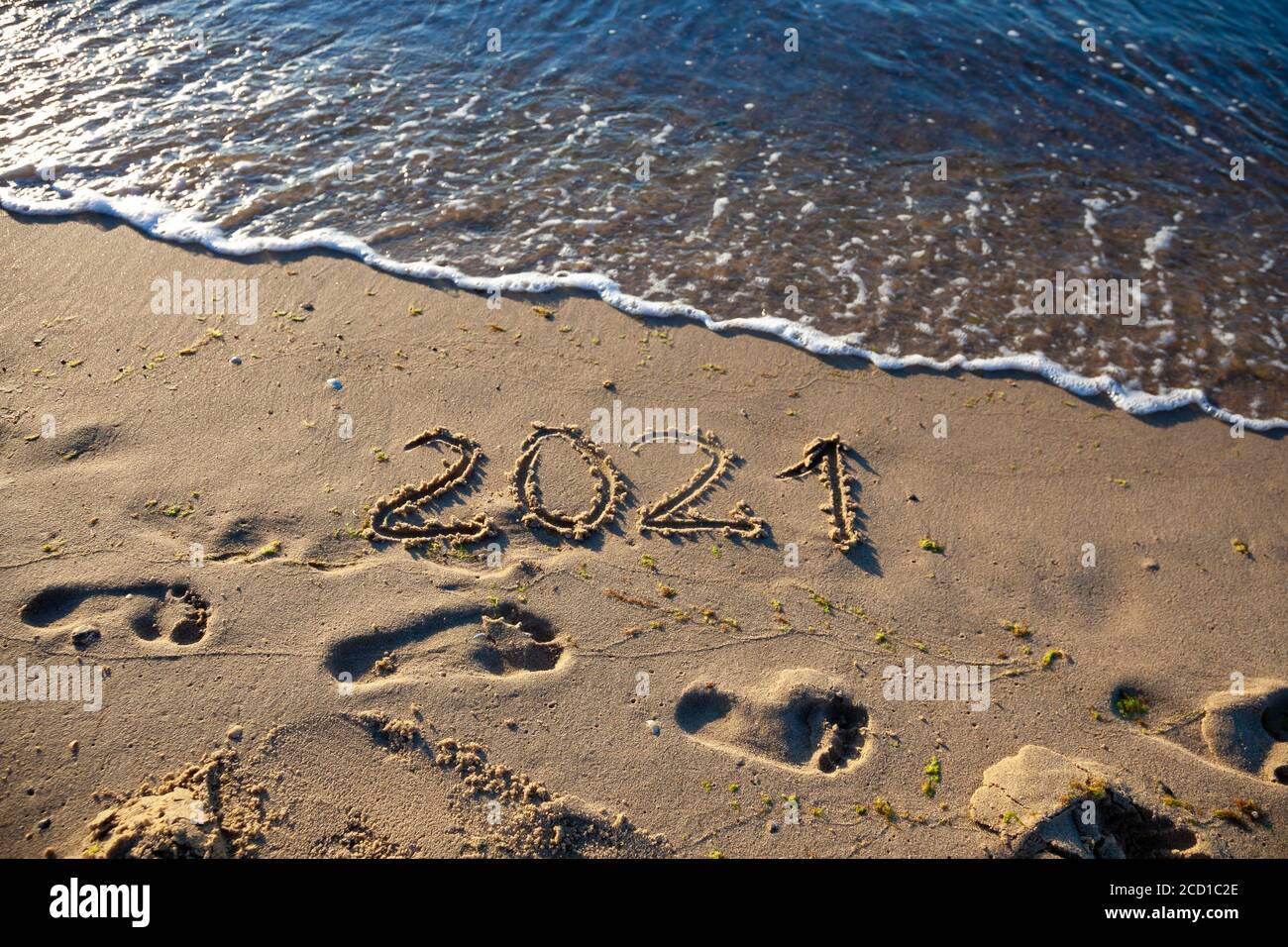 Les chiffres 2021 sont écrits dans le sable. Nouvel an sur la plage. Côte de mer, vague. Arrière-plan naturel. Place pour votre texte. Été en hiver. Banque D'Images