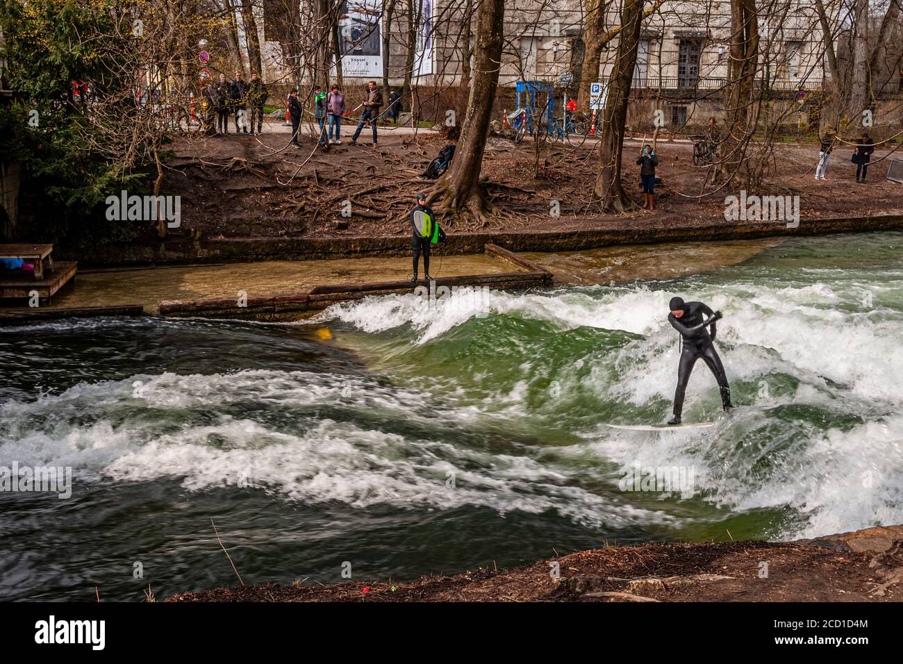 Surf sur l'Eisbach à Munich, Allemagne. La vague debout peut être surfée aussi longtemps que son solde est en attente, et dans les temps occupés une file d'attente de surfeurs se forme sur la banque Banque D'Images