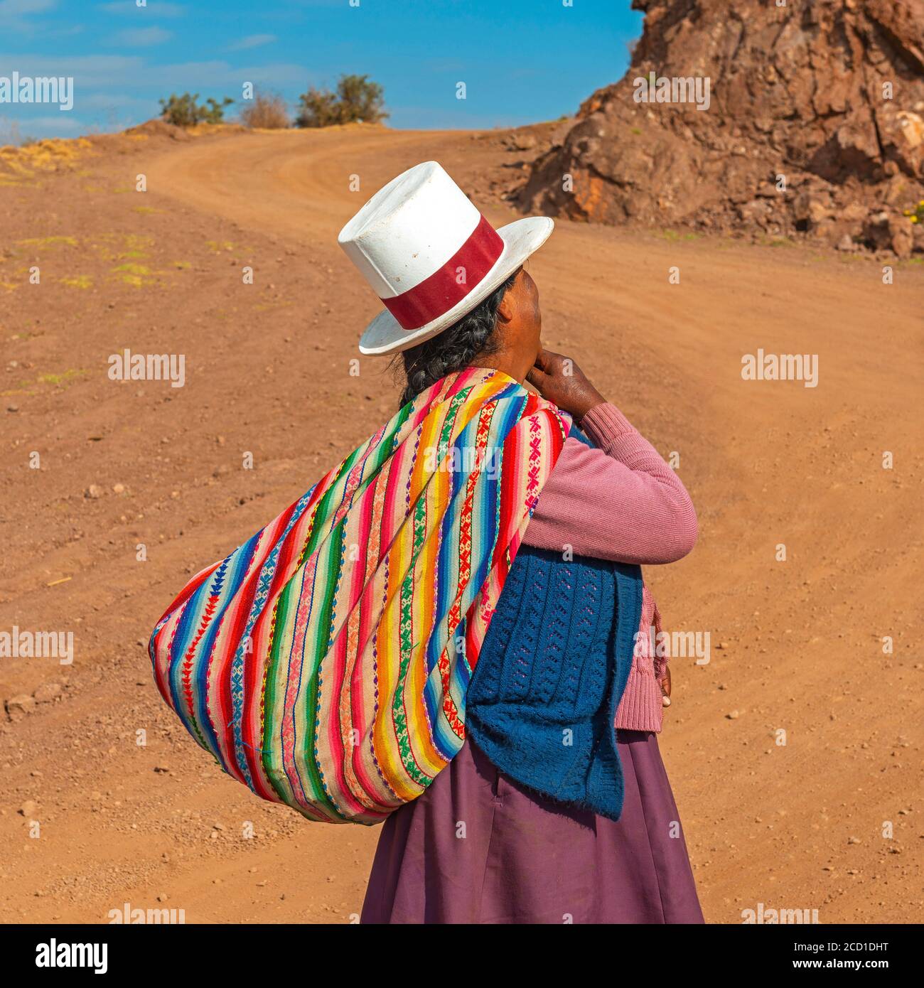 Autochtone péruvienne Quechua femme avec chapeau traditionnel et textile le long d'une route des Andes, Vallée Sacrée de l'Inca, Cusco, Pérou. Banque D'Images
