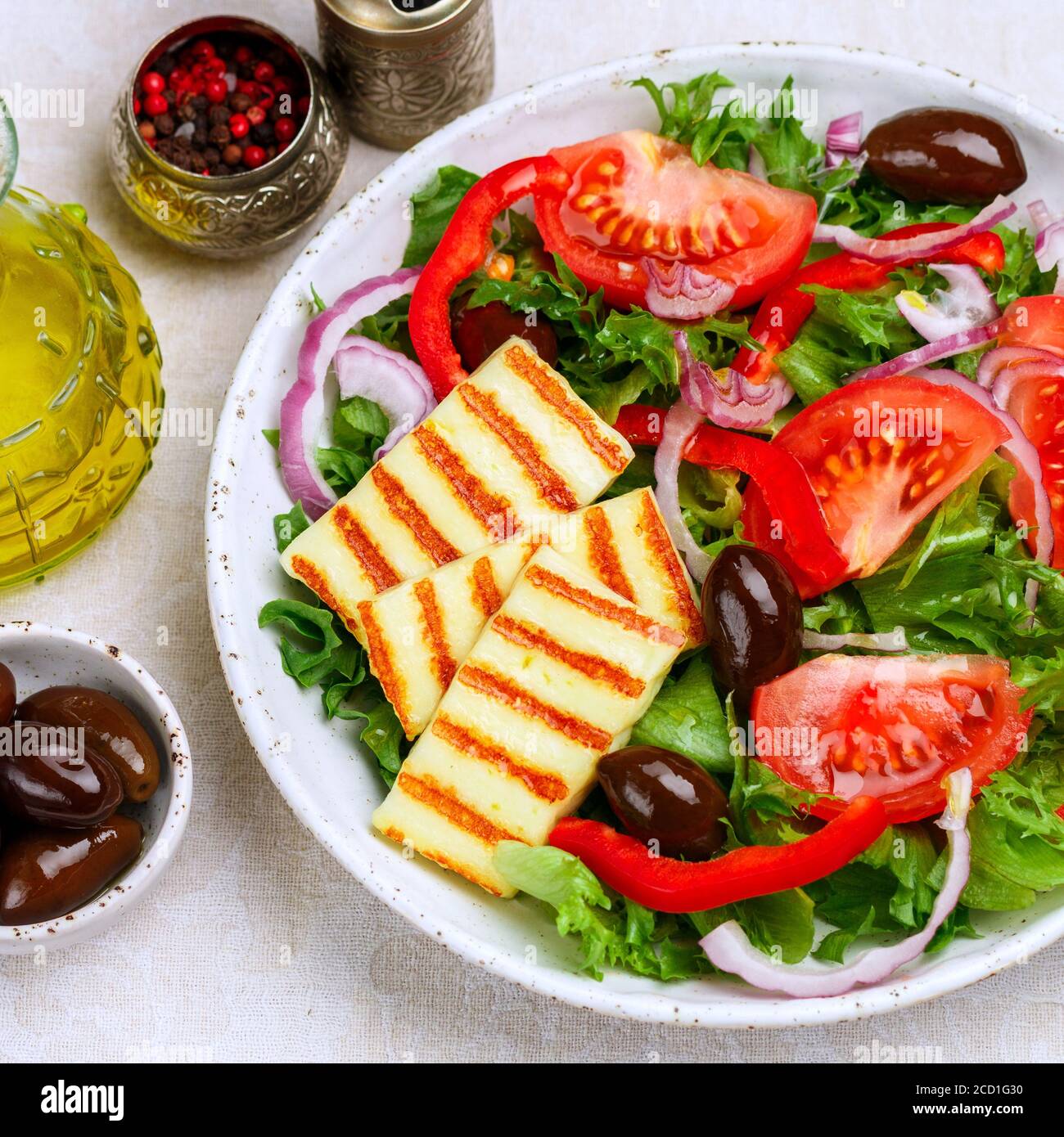 Salade délicieuse au fromage halloumi grillé, laitue, tomates, poivrons, oignons rouges, olives Kalamata, huile d'olive, épices. Cuisine méditerranéenne. Banque D'Images