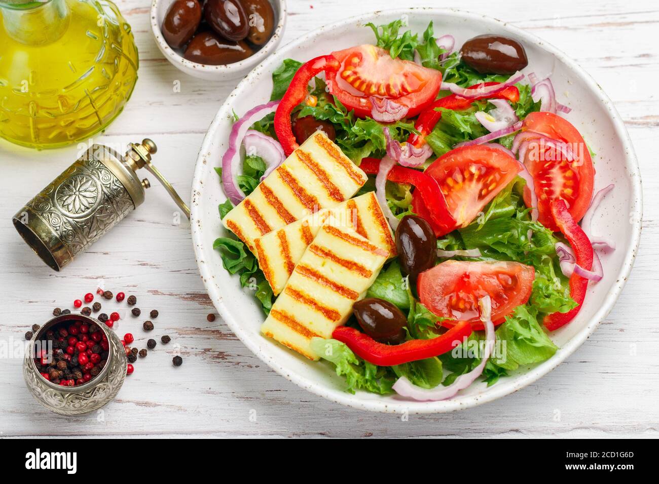 Salade délicieuse au fromage halloumi grillé, laitue, tomates, poivrons, oignons rouges, olives Kalamata, huile d'olive, épices. Cuisine méditerranéenne. Banque D'Images