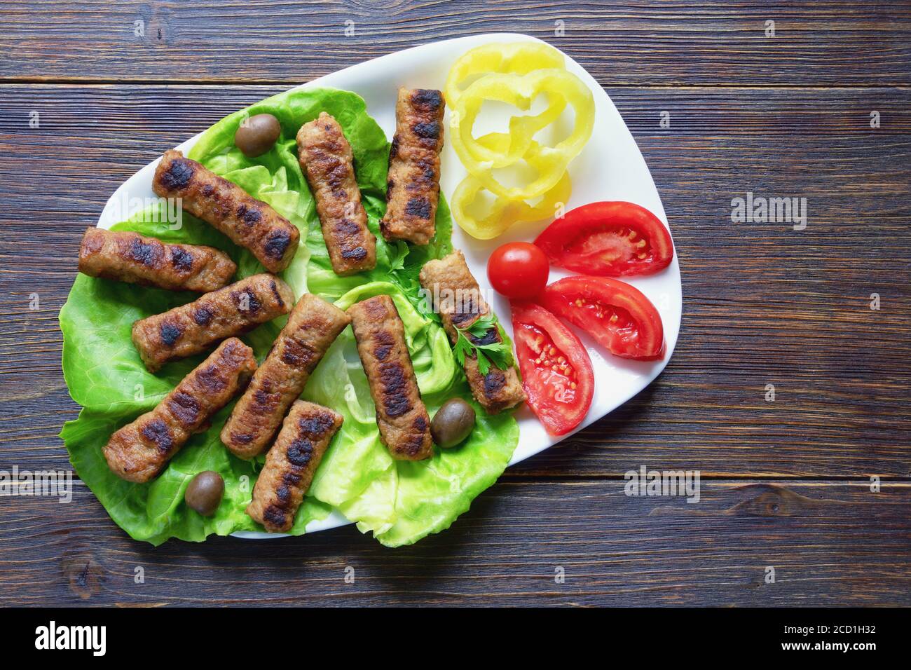 Cuisine des Balkans. Cevavi - plat grillé de viande hachée sur une table rustique. Flat lay, espace de copie Banque D'Images