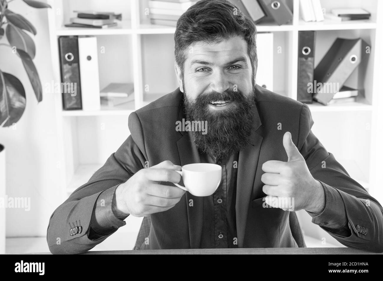 Mon énergie. Un homme beau patron assis dans le bureau buvant du café. Espace de travail confortable. Bonjour. Boxer taille basse à barbe classique décontracté avec café. Les routines de vie de bureau. pdg respectable. Premier café. Banque D'Images