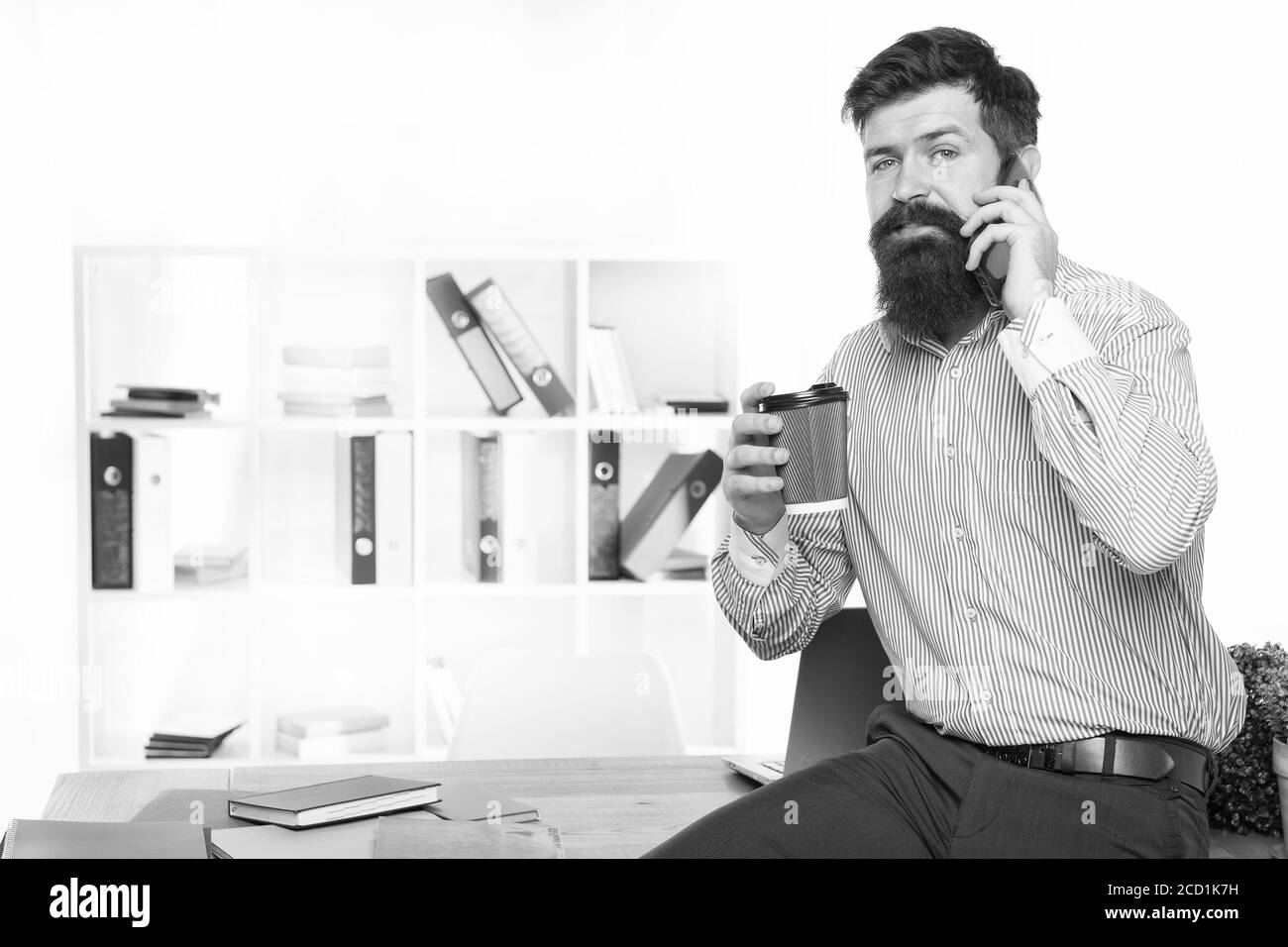 Connexion à un téléphone portable. Un barbu parle au téléphone en train de boire du café. Obtenir un appel téléphonique. Vie professionnelle. Marketing numérique avec téléphone mobile. Communication d'entreprise. Nouvelle technologie. Style de vie moderne. Banque D'Images