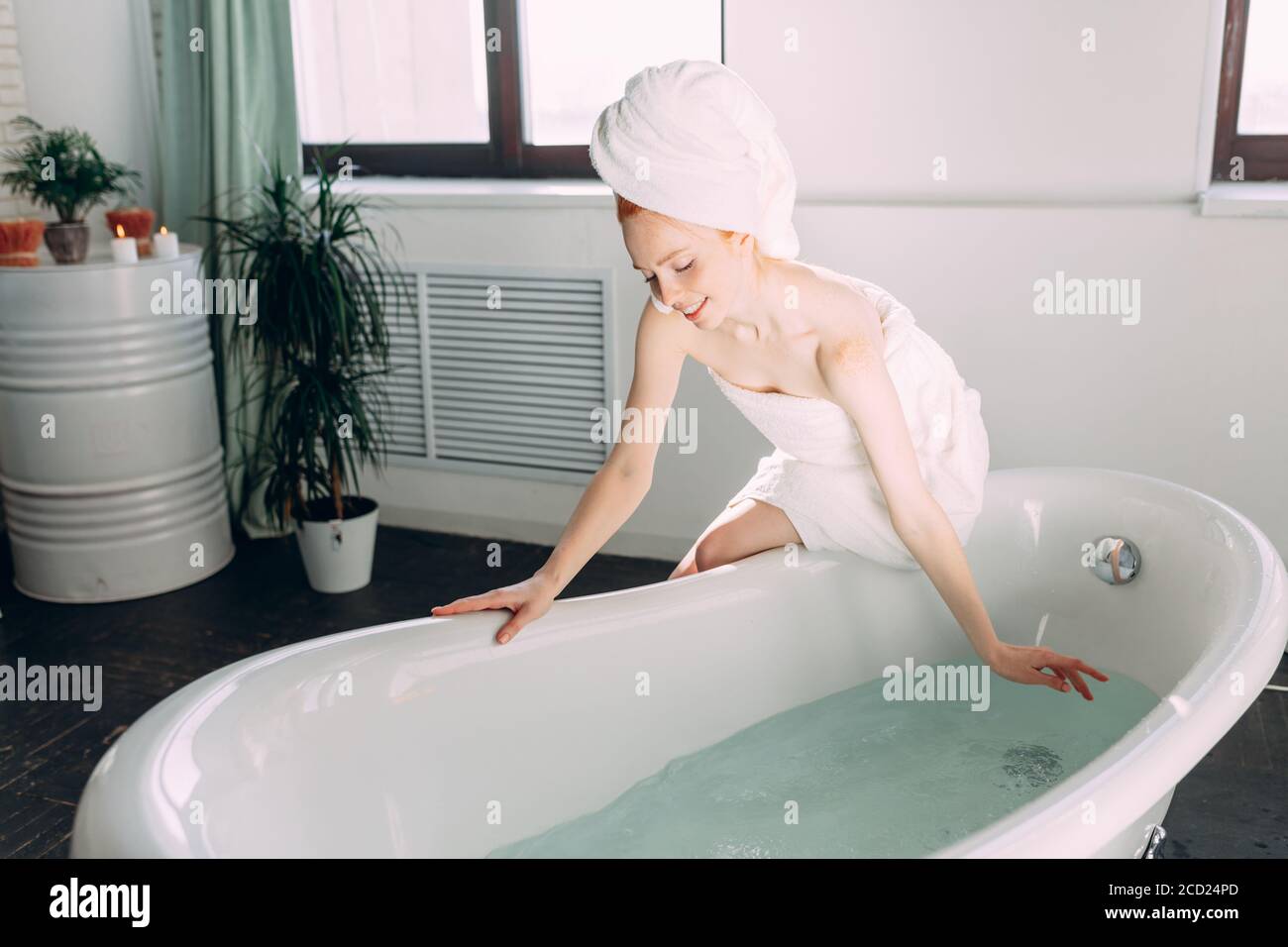 Belle femme en bain va laver son corps dans la baignoire à la maison,  vérifier l'eau avec la main, profiter de minutes de tranquillité et de  silence Photo Stock - Alamy