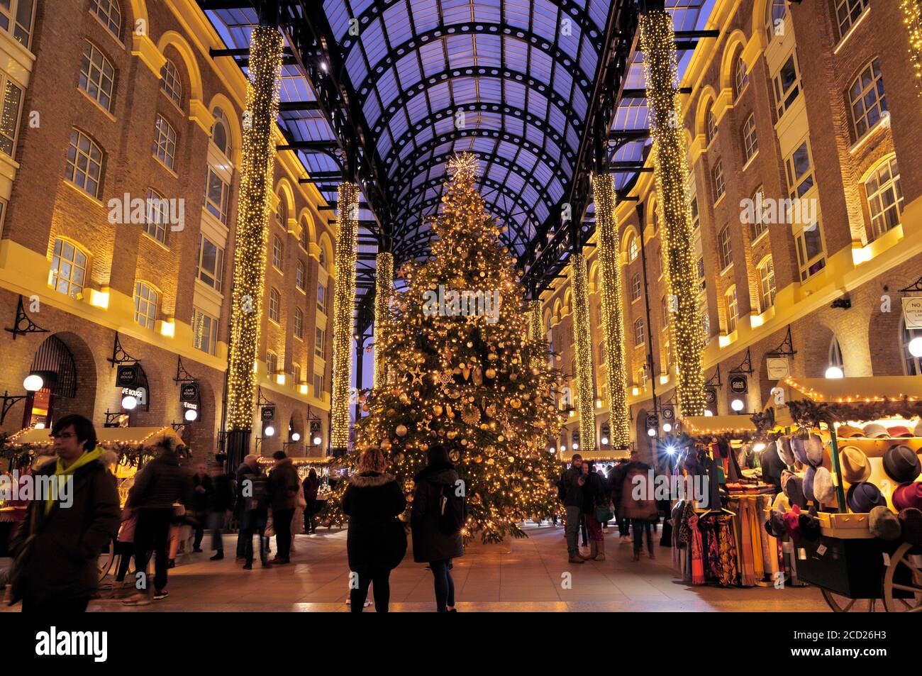 Lumières festives, étals de marché et un arbre de Noël magnifiquement décoré sous le toit voûté de Hay's Galleria, Londres, Angleterre, Royaume-Uni Banque D'Images