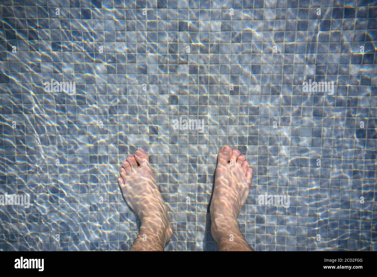 Les pieds dans la piscine le matin reflétant l'eau comme vagues. Mosaïque mélangée à gris foncé et gris clair Banque D'Images