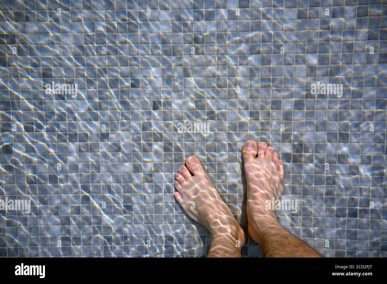 Les pieds dans la piscine le matin reflétant l'eau comme vagues. Mosaïque mélangée à gris foncé et gris clair Banque D'Images