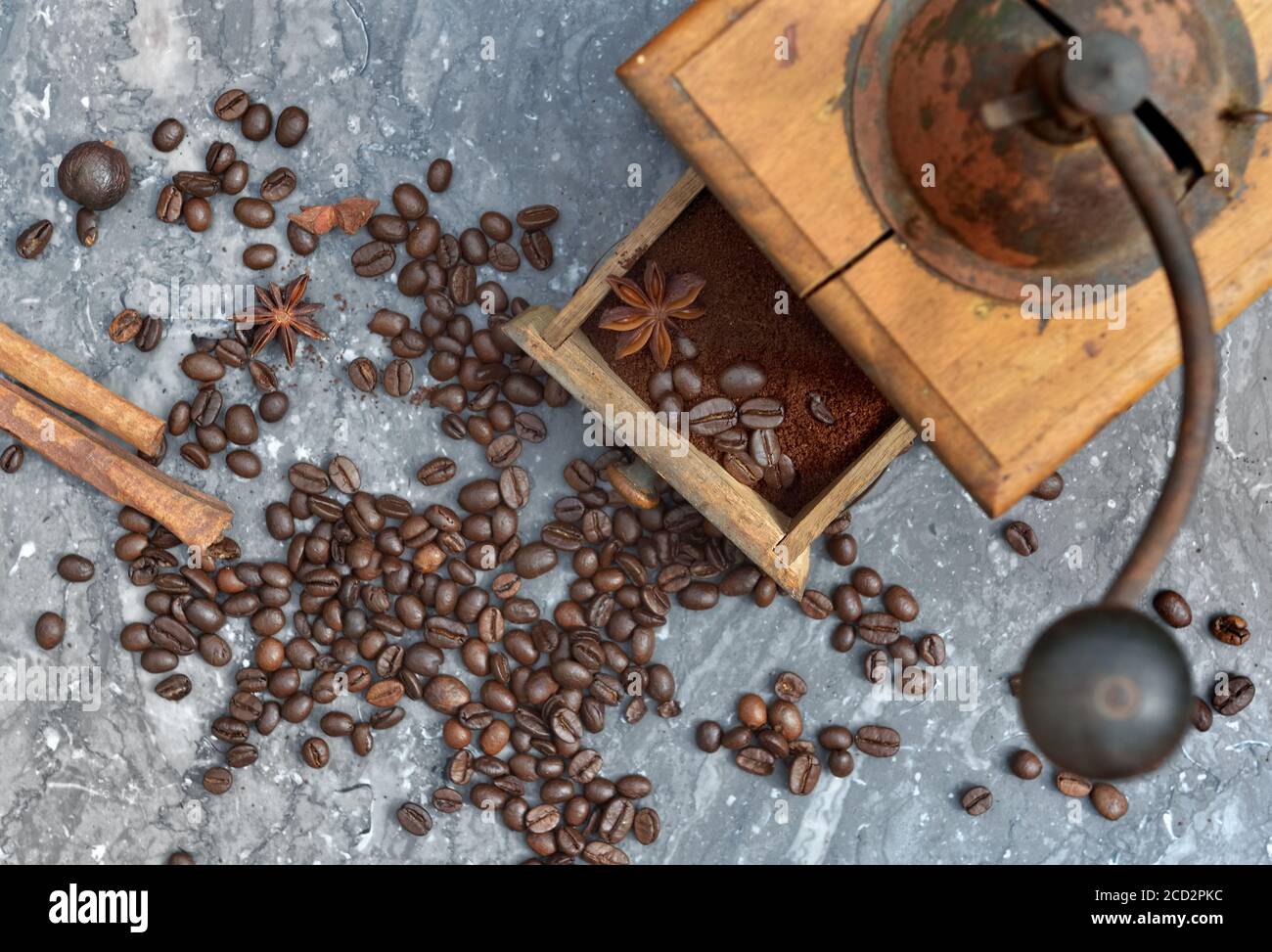 vue de dessus sur l'ancien moulin à café plein de café et haricots avec épices sur fond de marbre gris Banque D'Images