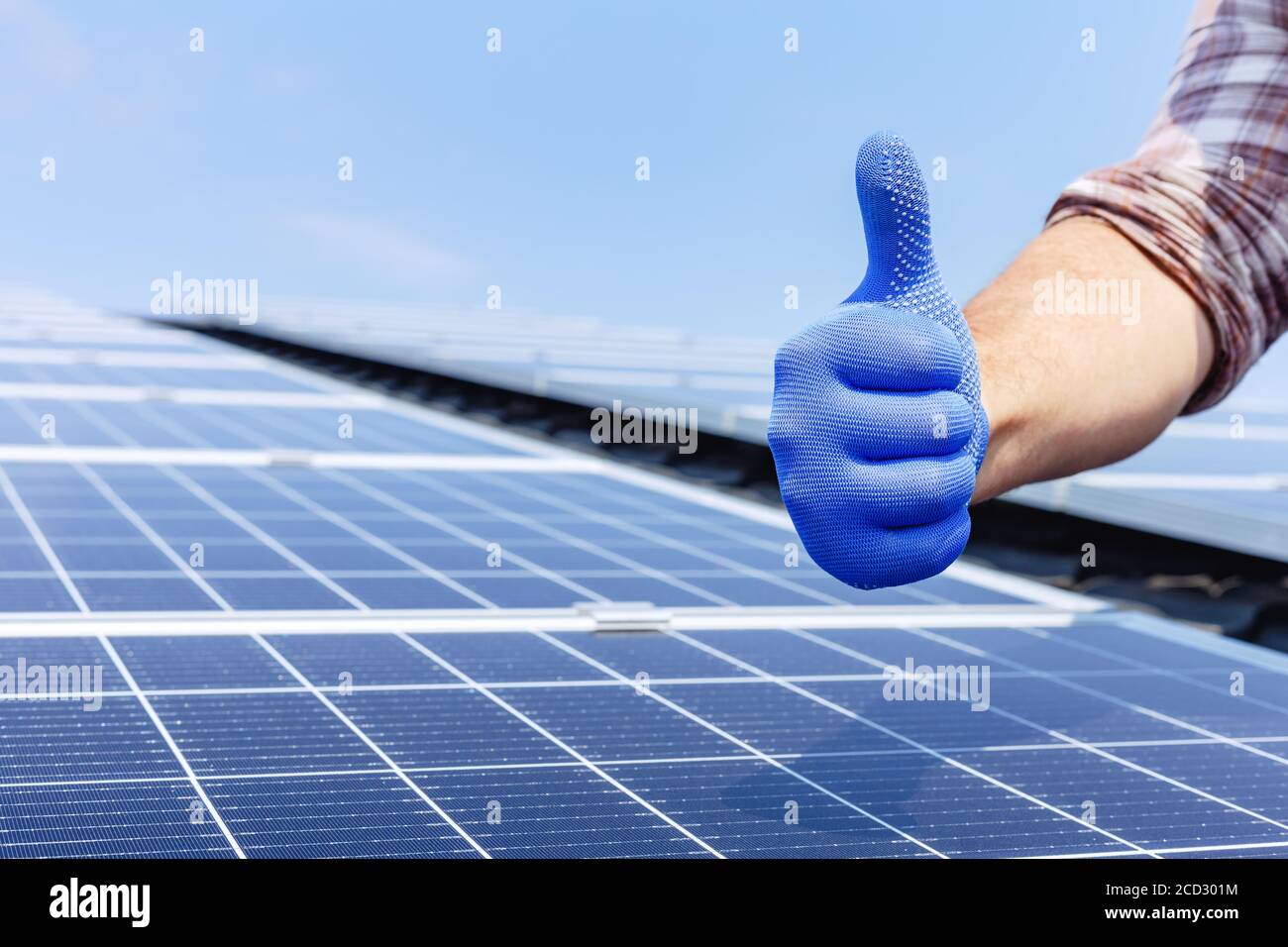 Homme travailleur montrant le pouce vers le haut, geste positif contre panneau solaire, station solaire. Comme à l'énergie solaire alternative. Homme installant solaire Banque D'Images