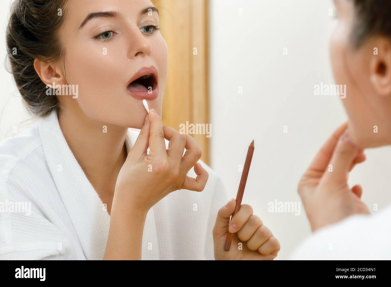 Femme traçant le contour de la lèvre avec un crayon Banque D'Images